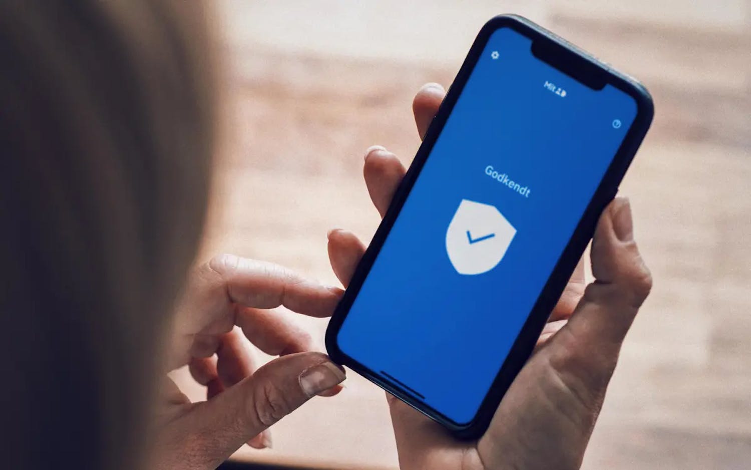 MItID stopper med at virke En kvinde benytter MitID-app'en på sin telefon